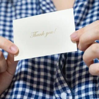 Thank youと書かれたメッセージカードを手渡すイメージ