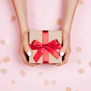 リボンをかけたプレゼントを手渡すイメージ